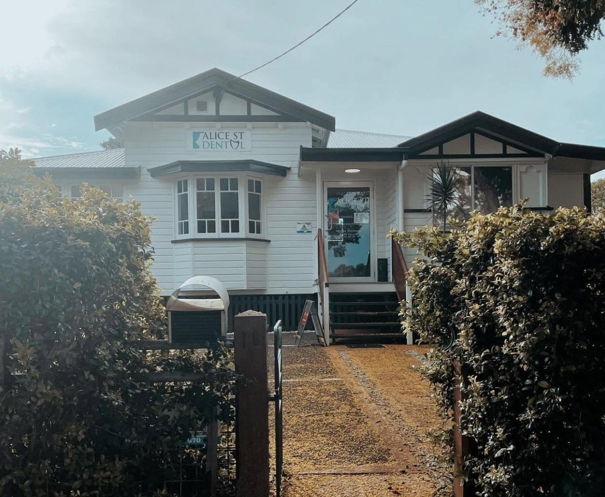 The Alice St Dental building, a white Queenslander with a blue sign